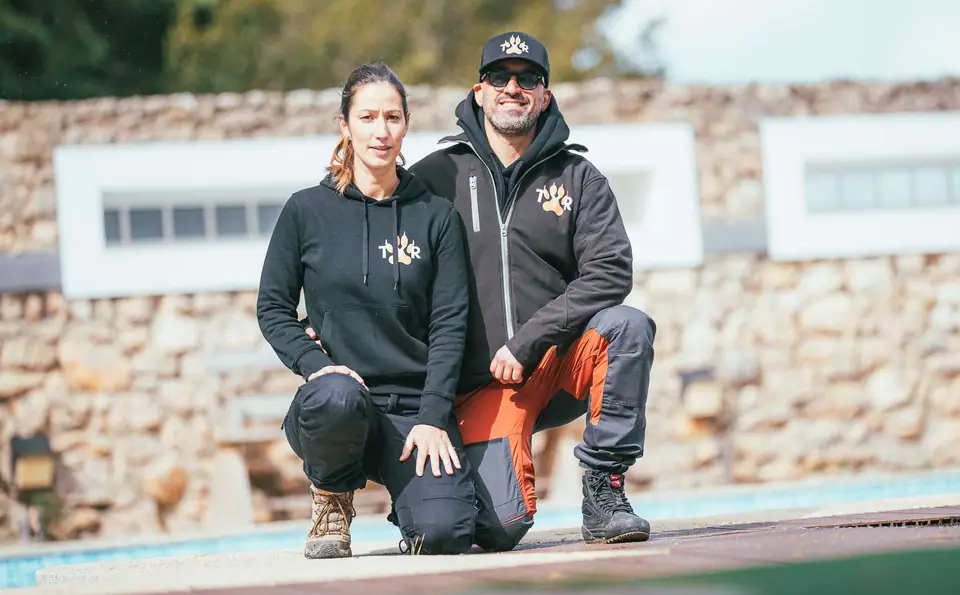 Sandra Freitas e Rui Navarro, de joelhos lado a lado, junto a uma parede de pedra
